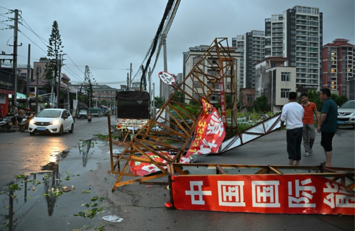 People remove a fallen iron gate after Typhoon Ragasa passed through Yangjiang, in southern China's Guangdong province on September 24, 2025