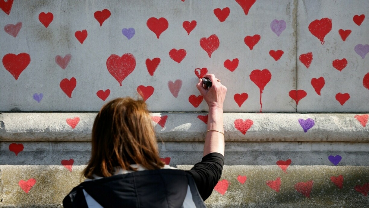 Red hearts are painted onto the wall of the embankment on the south side of the River Thames in memory of those who lost their lives to Covid-19 in London on March 29, 2021. A mural made up of almost 150,000 hand-drawn hearts is being painted to remember the victims of the coronavirus crisis.