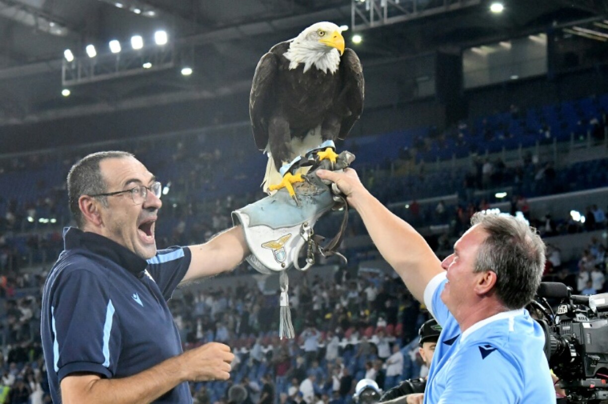 L'entraîneur de la Lazio Rome Maurizio Sarri pose avec l'aigle Olimpia, la mascotte du club, après la victoire contre la Roma, lors d de leur derby en Serie A, le 26 septembre 2021 au Stadio Olimpico à Rome