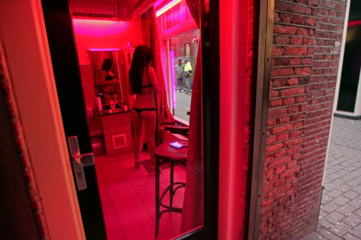 Une prostituée attend des clients derrière une vitrine du Quartier rouge d'Amsterdam, le 8 décembre 2008.