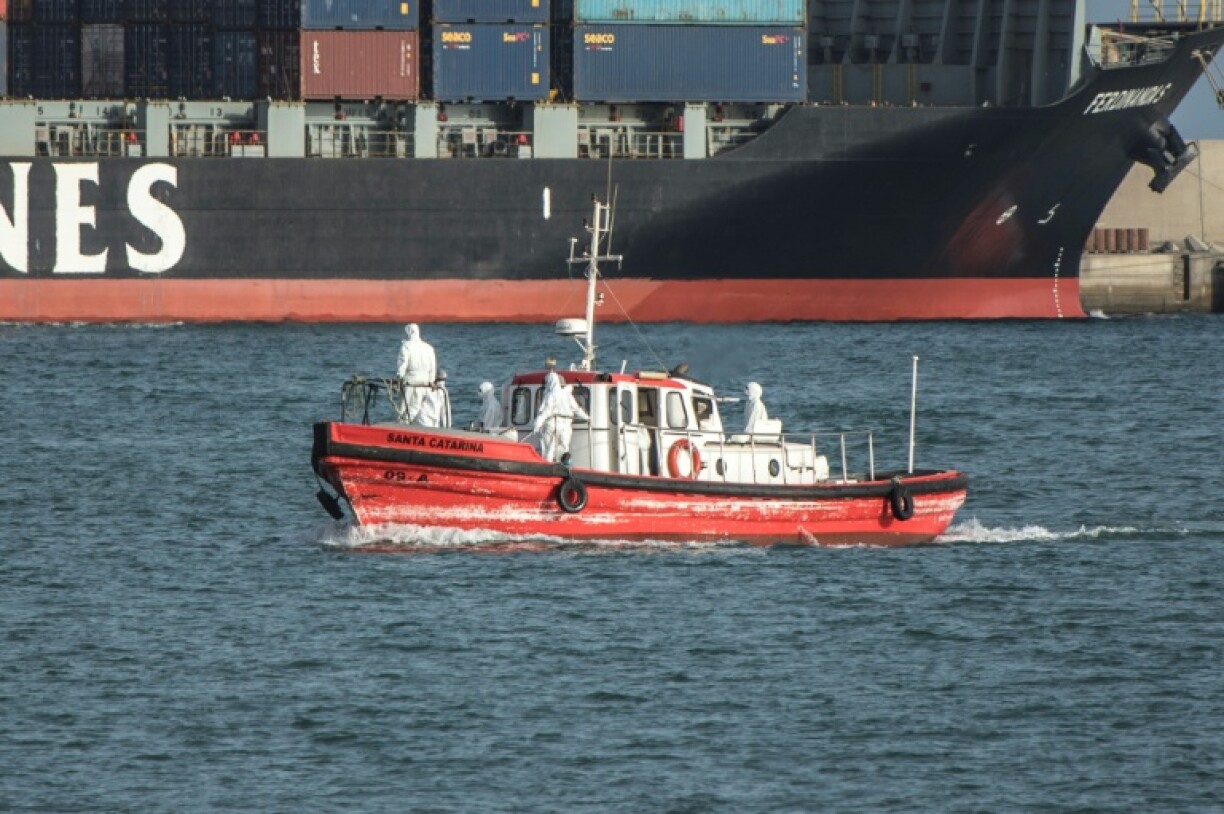 Un bateau-ambulance, transportant des membres d'équipage en combinaisons de protection, retourne au port de Praia, après une visite au paquebot MV Hondius, stationné au large, le 5 mai 2026 au Cap-Vert