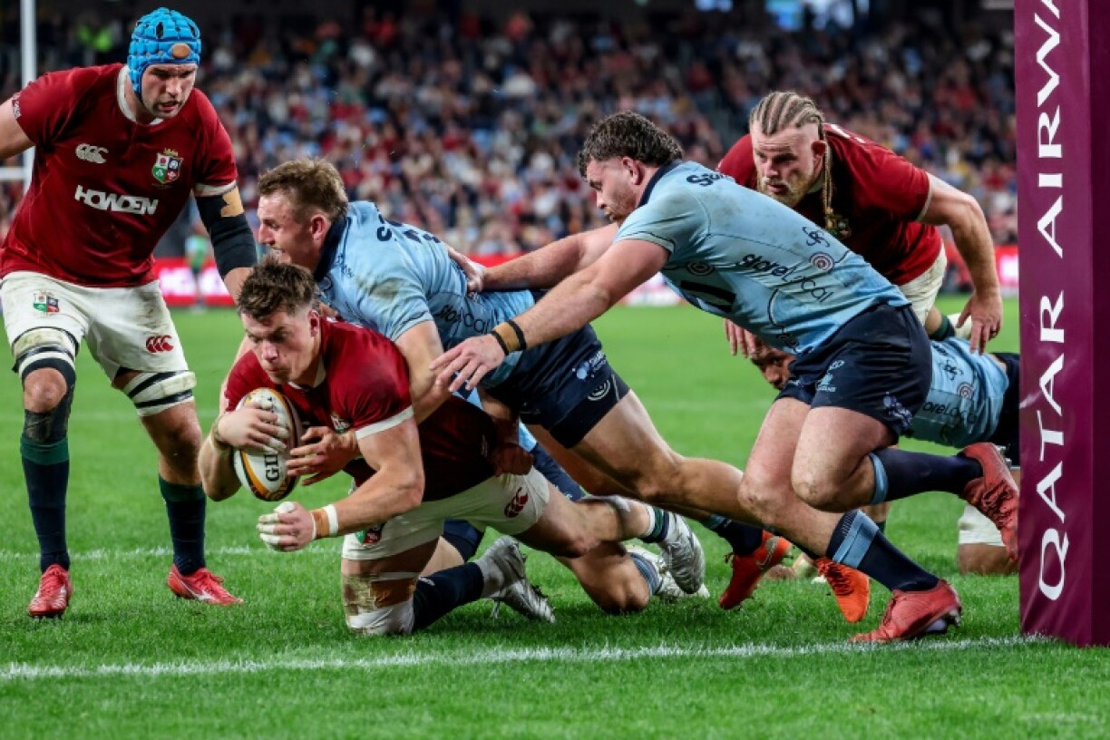 British and Irish Lions' Huw Jones (bottom) scores a try against the NSW Waratahs
