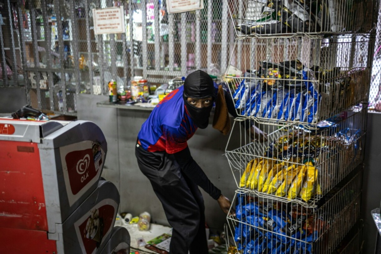 A looter removes goods from a shop in Soweto following clashes between local residents and foreign nationals