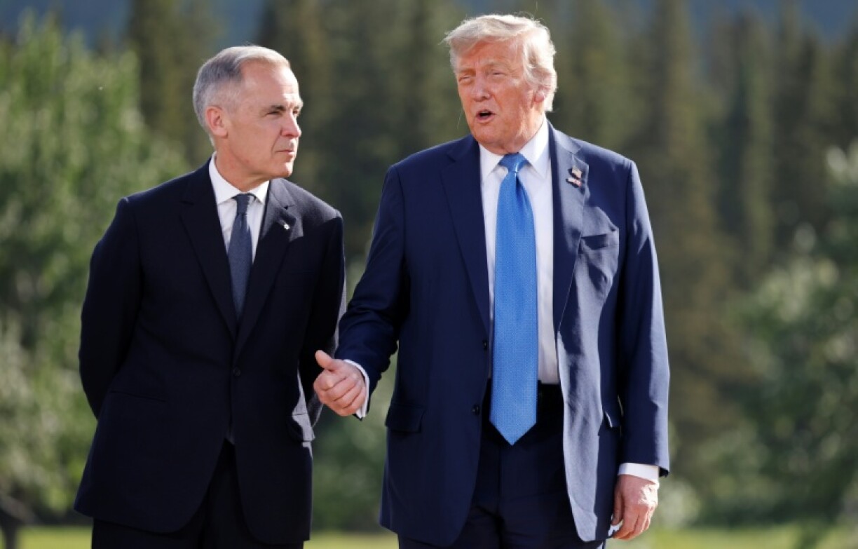 Canadian Prime Minister Mark Carney and US President Donald Trump talk during a photo session at the Group of Seven Summit