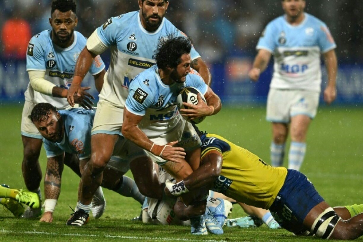 Bayonne's French scrum-half Maxime Machenaud (C) is tackled during the French Top14 play-off against Clermont in south-western France