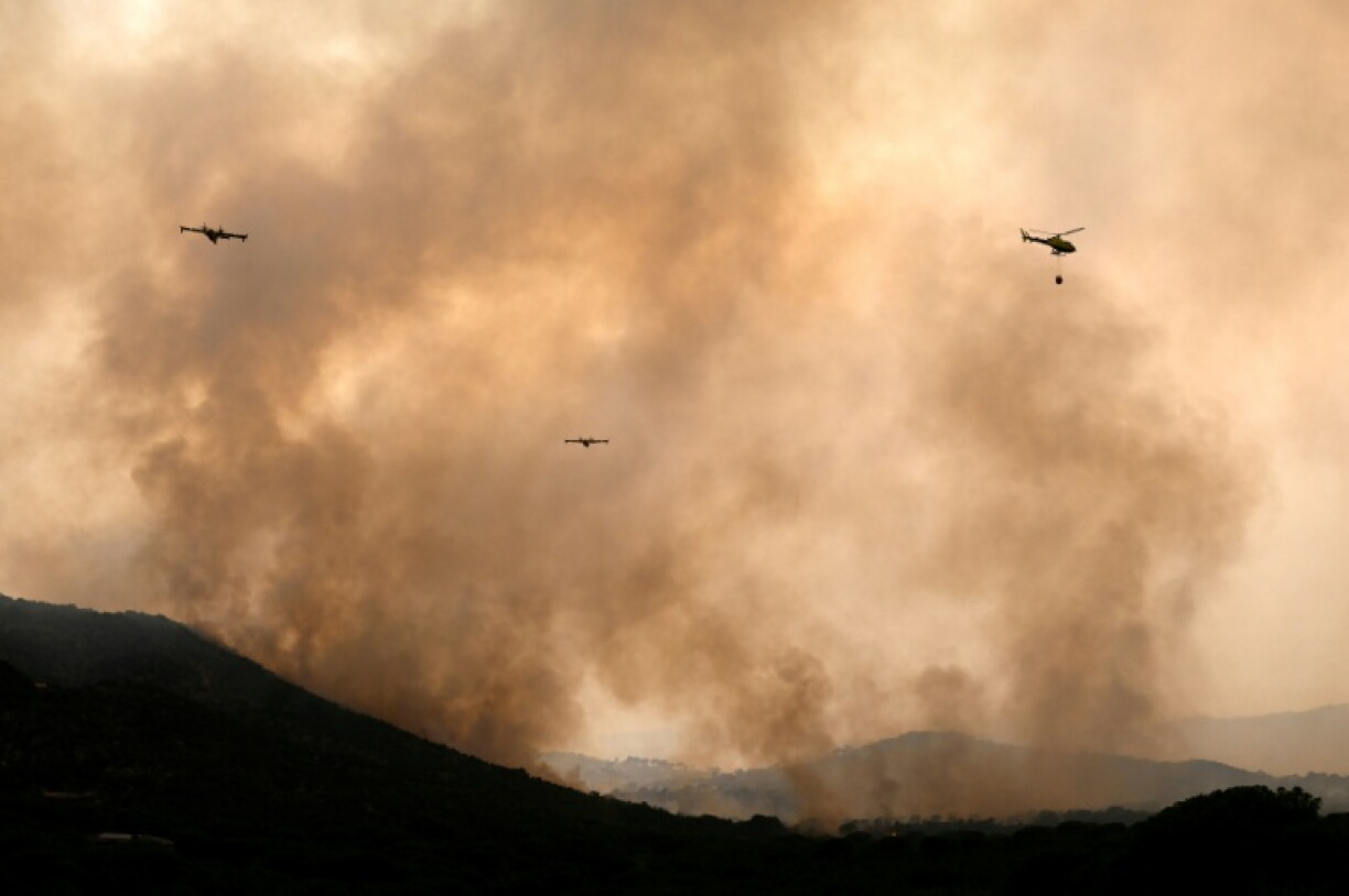 Des avions de lutte contre les incendies larguent de l'eau sur un feu de forêt près du village de Cebreros, dans la province d'Ávila, en Espagne, le 27 juillet 2026