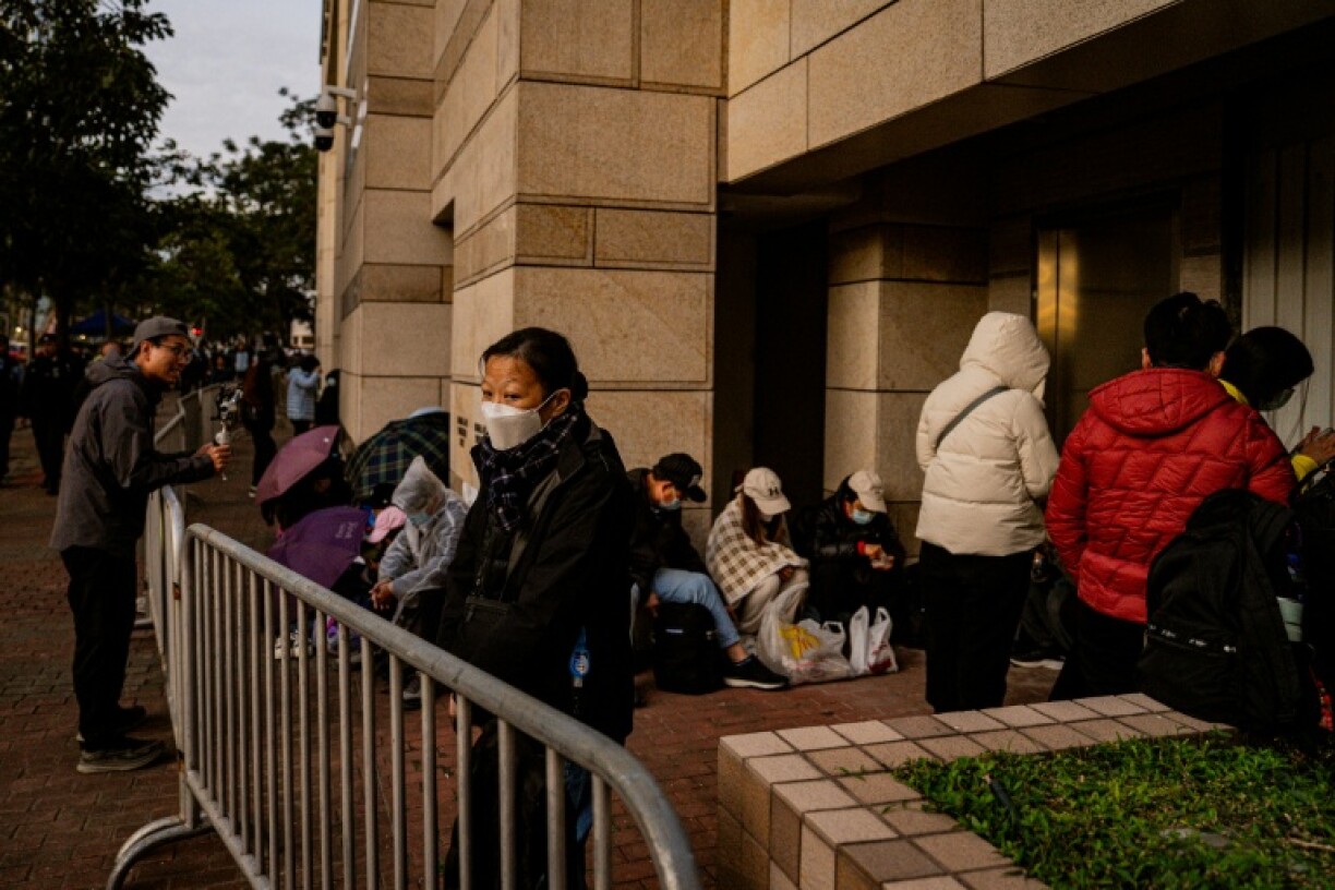 Des personnes attendent devant le tribunal de West Kowloon pour le verdict dans le procès de Jimmy Lai, le 15 décembre 2025 à Hong Kong
