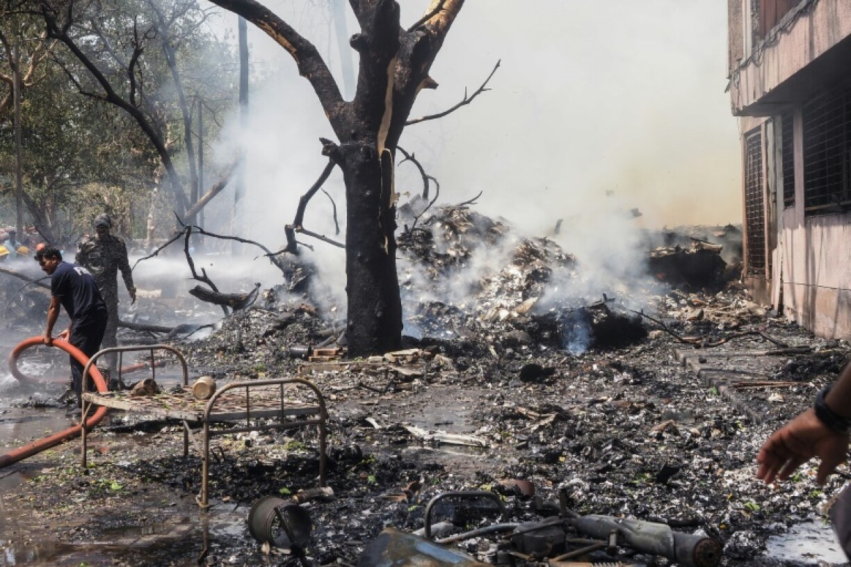 Firefighters work at the site where Air India flight 171 crashed