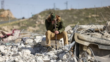 Un membre de la famille Salhab pleure, assis sur les décombres d'un immeuble d'appartements après sa démolition par des bulldozers israéliens près de la colonie israélienne de Hagai, au sud de la ville d'Hébron, en Cisjordanie occupée, le 18 février 2026.