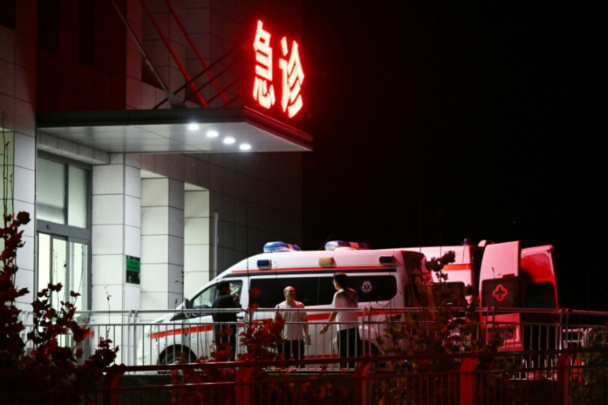 Des hommes se tiennent près d'ambulances devant l'Hôpital populaire du canton de Qinyuan, à 20 km de la mine de charbon de Liushenyu, où des dizaines de mineurs ont trouvé la mort vendredi après une explosion