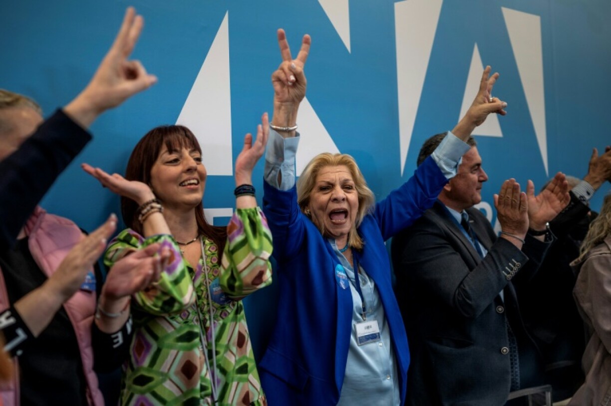 Des partisans du Premier ministre grec sortant Kyriakos Mitsotakis réagissent aux sondages réalisés à la sortie des urnes donnant le parti conservateur en tête aux législatives, le 21 mai 2023 à Athènes