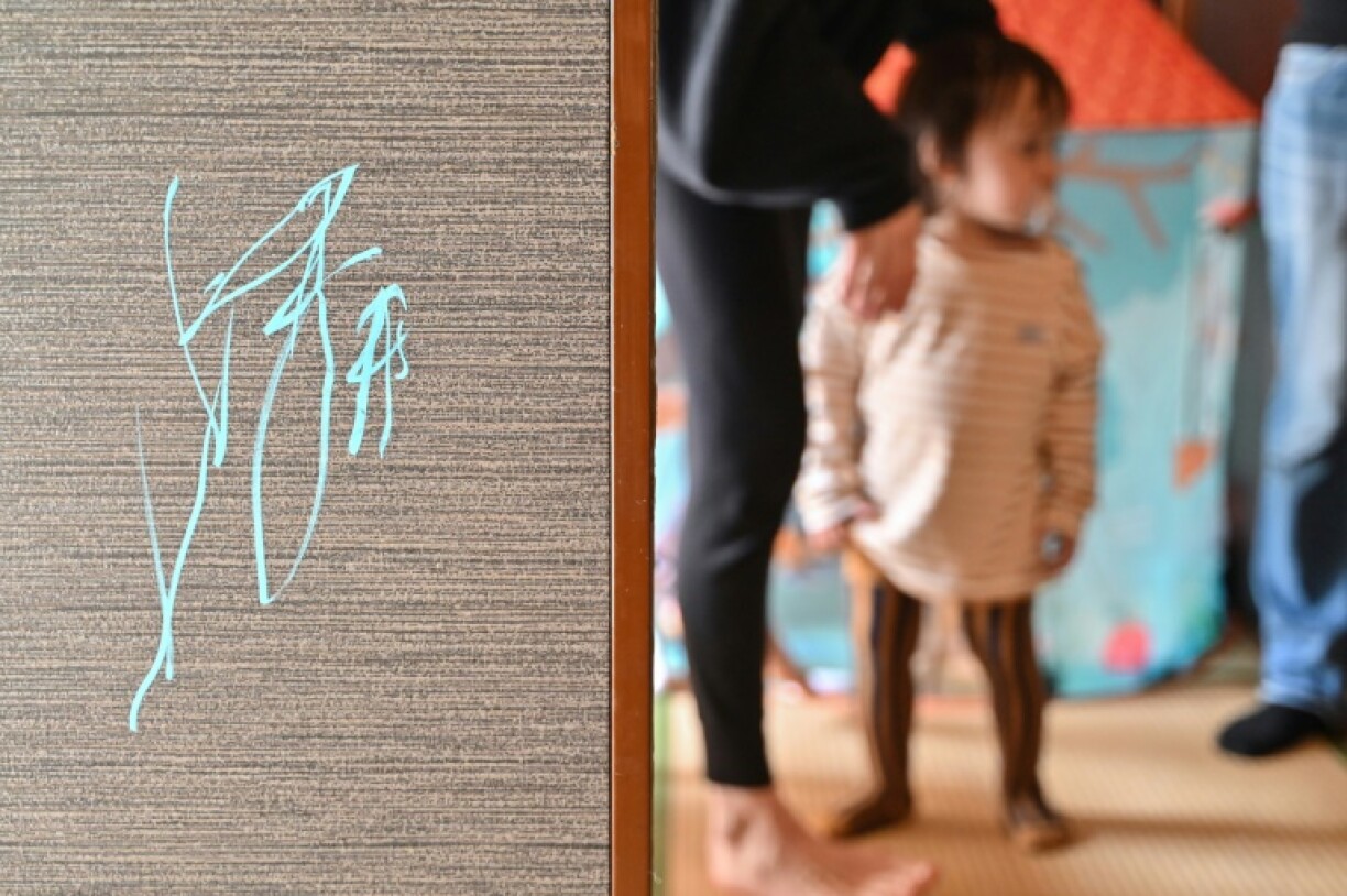 A drawing (L) on the side of a sliding screen door at the home of 21-month-old artist