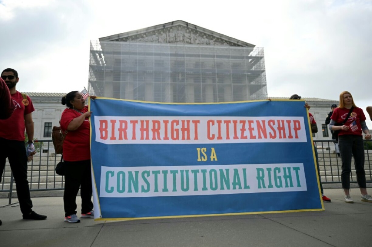 Protestors hold a sign outside the US Supreme Court as it debates President Donald Trump's move to end automatic birthright citizenship