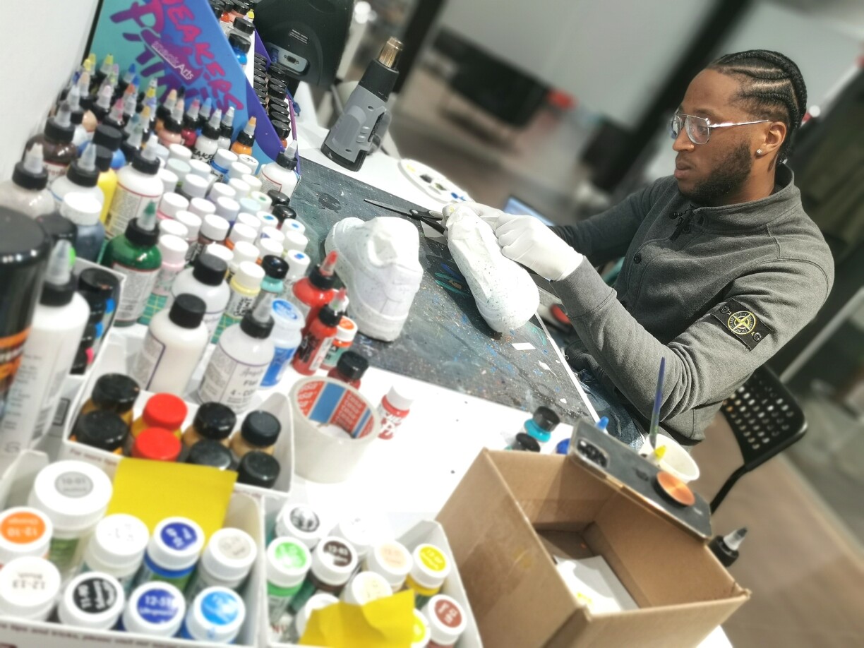 Zachary Boudou cleans, restores, and customises trainers at the 'Sneak-In' shop in Esch-sur-Alzette.