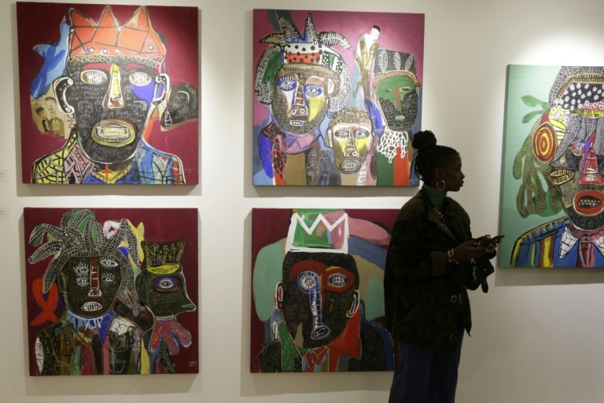 A visitor walks past artworks by Cameroonian artist Hako Hankson during the 1-54 Marrakesh Contemporary African Art Fair