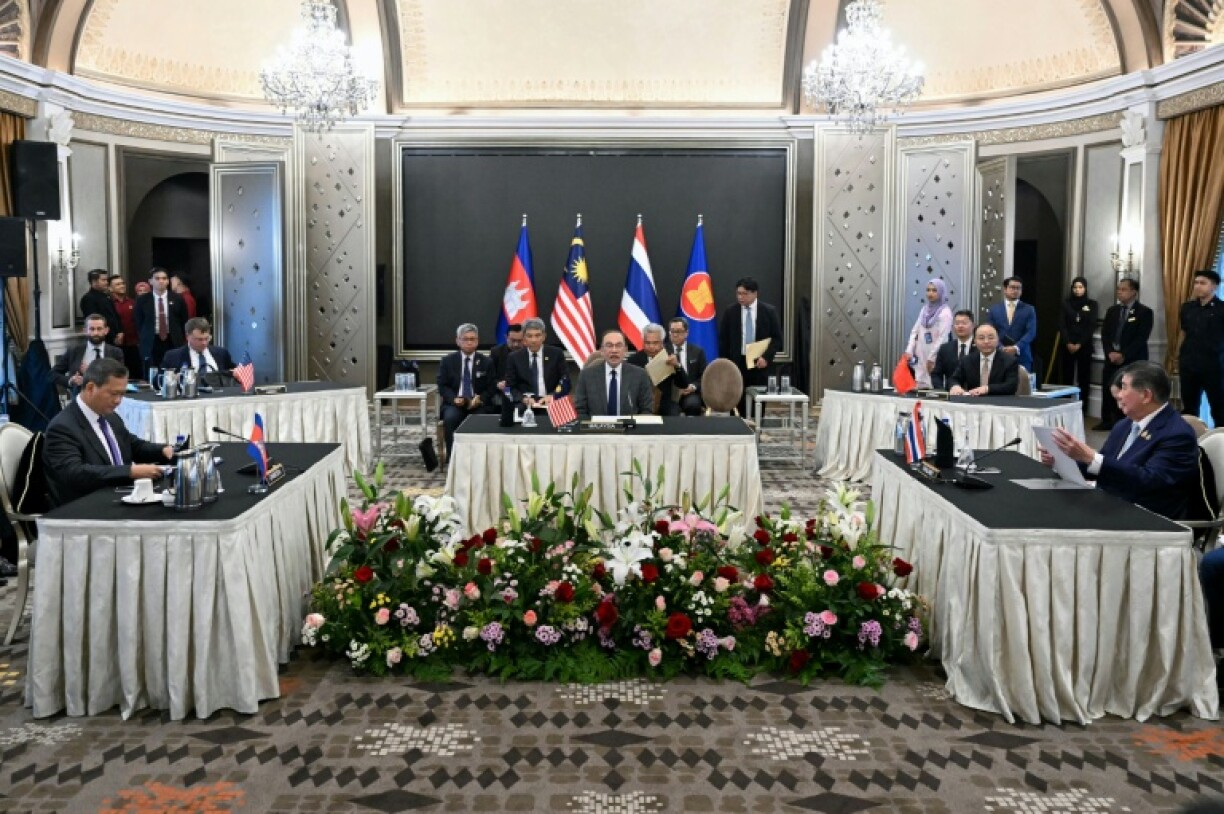 Malaysia's Prime Minister Anwar Ibrahim (centre) looks on as Cambodia's Prime Minister Hun Manet (left) and Thailand's acting Prime Minister Phumtham Wechayachai (right) take part in talks on a possible ceasefire in Putrajaya