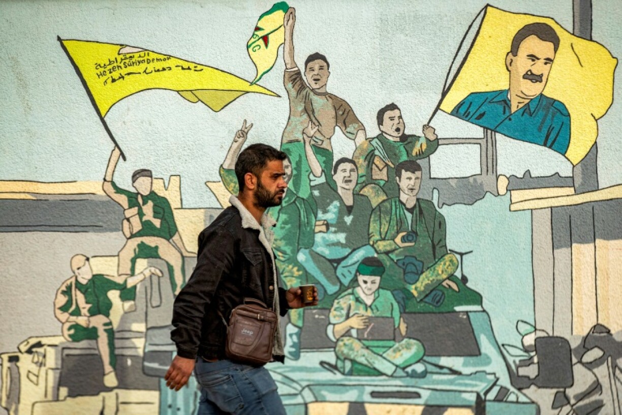 A mural in northern Syria showing Kurdish fighters with a flag bearing Ocalan's face