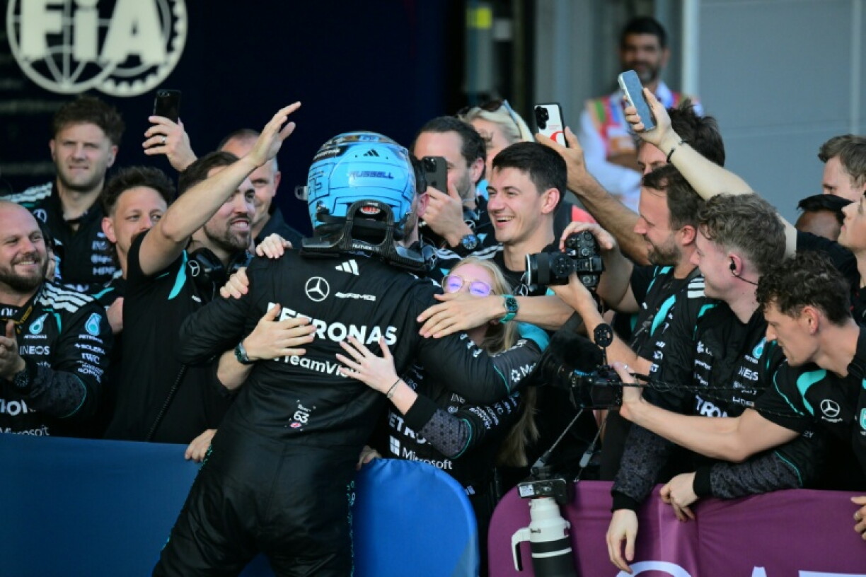 A grateful George Russell celebrates with the Mercedes pit crew after victory in Baku