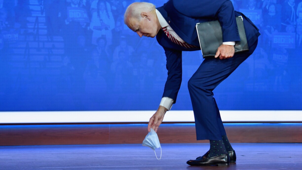 Democratic presidential nominee and former Vice President Joe Biden picks up his mask after dropping it at the end of his speech on Covid-19 at The Queen theater on October 23, 2020 in Wilmington, Delaware.
