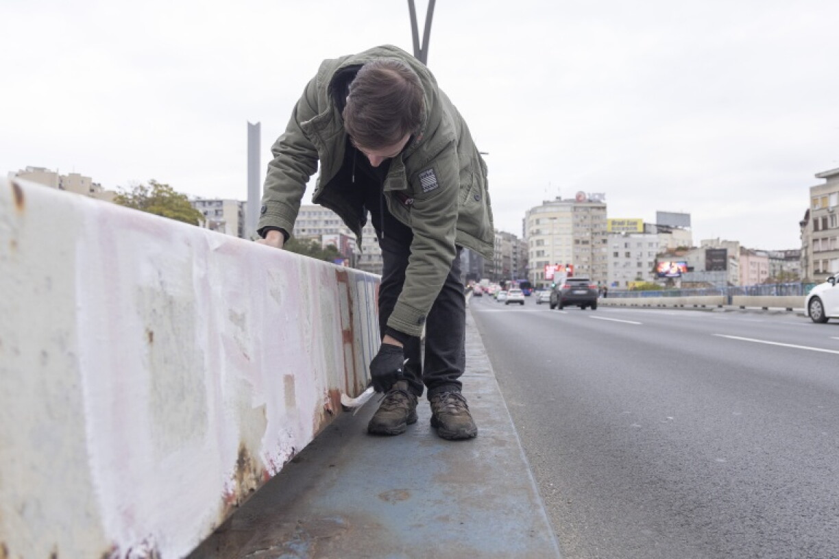 A Belgrade resident paints over politically charged graffiti during a clean-up campaign in the Serbian capital on October 28, 2026, days after a student-backed list won the country's snap parliamentary elections. The campaign, backed by the student-led movement, aims to remove graffiti, rubbish and other traces of nearly two years of political protests and restore public spaces across the city.