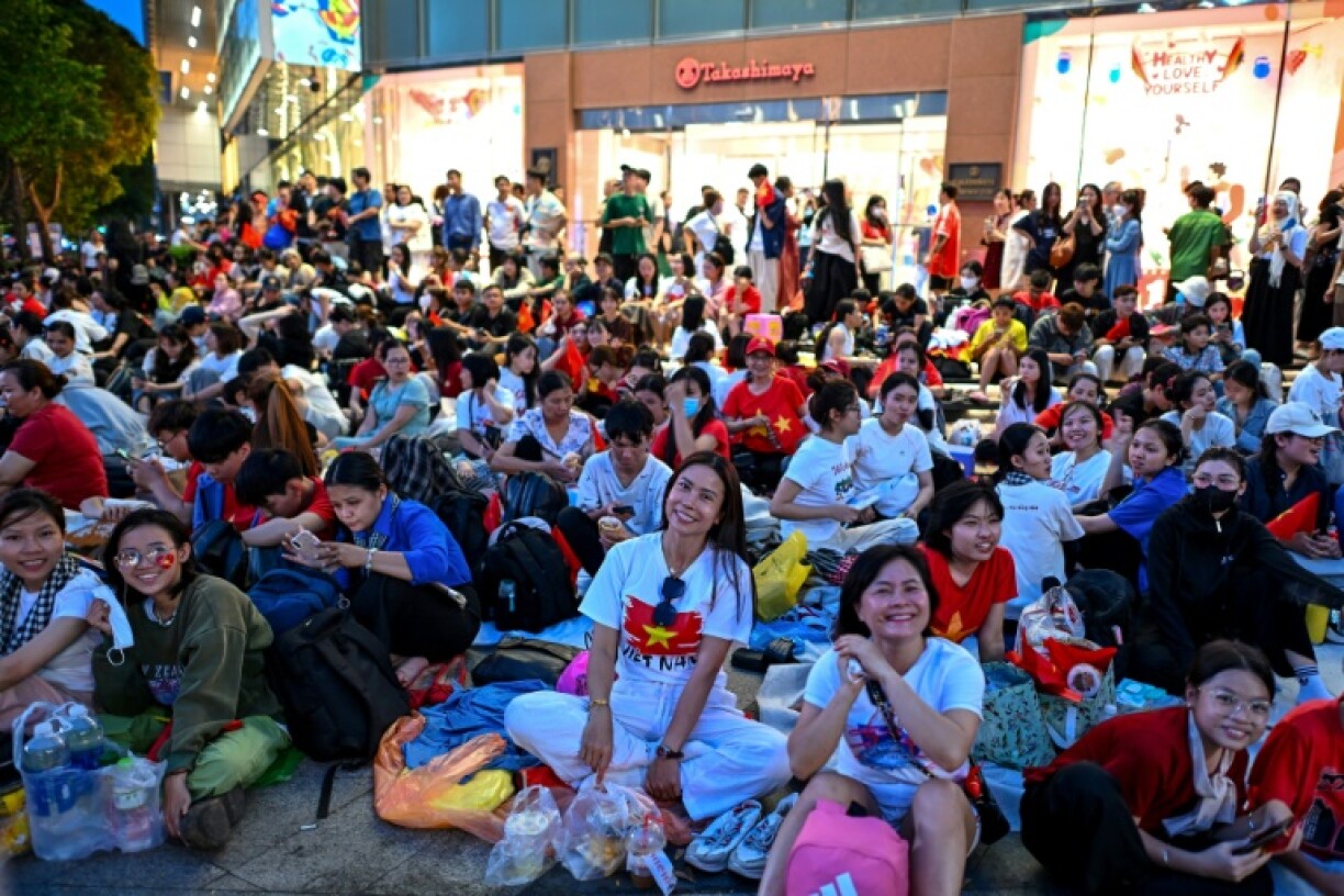Vietnamese gather on the streets of Ho Chi Minh City, preparing to sleep out overnight ahead of the start of a parade marking the 50th anniversary of the fall of Saigon