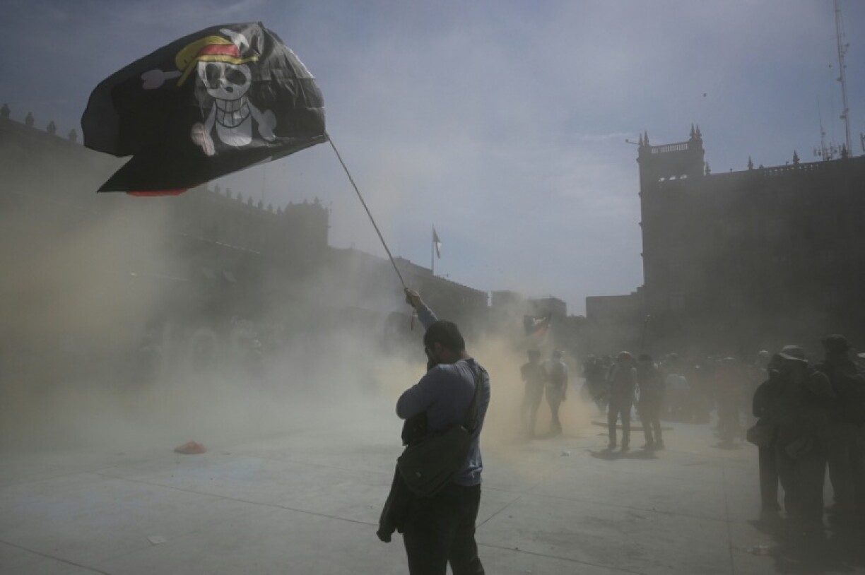Un homme brandit le drapeau du manga One Piece lors d'une manifestation antigouvernementale à Mexico le 15 novembre 2025