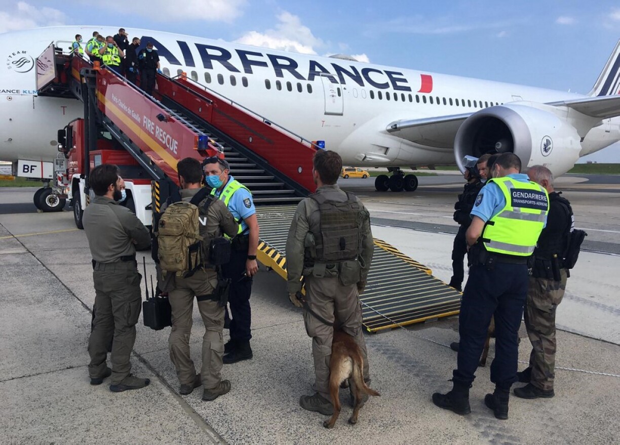 A handout photo made available by the Gendarmerie Nationale shows gendarmes from the GIGN and air transport unit on the runway of Roissy-Charles de Gaulle airport after they control passengers following a bomb threat on a flight from Chad to Paris on June 3, 2021.