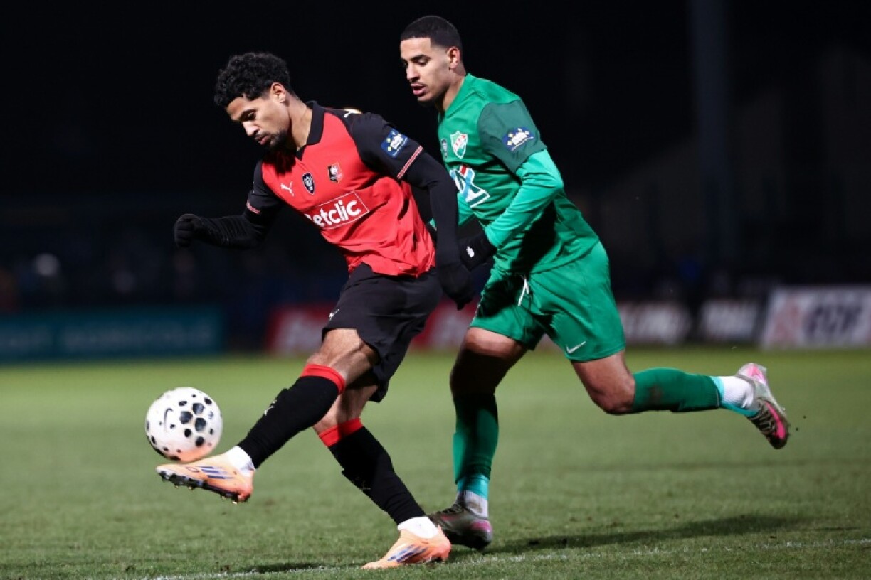 Le joueur de Rennes Ludovic Blas, en rouge, face à celui de Chantilly Yacine Boucharoud, en vert, lors du 16e de finale de Coupe de France remporté par le club breton, le 11 janvier 2026, à Beauvais