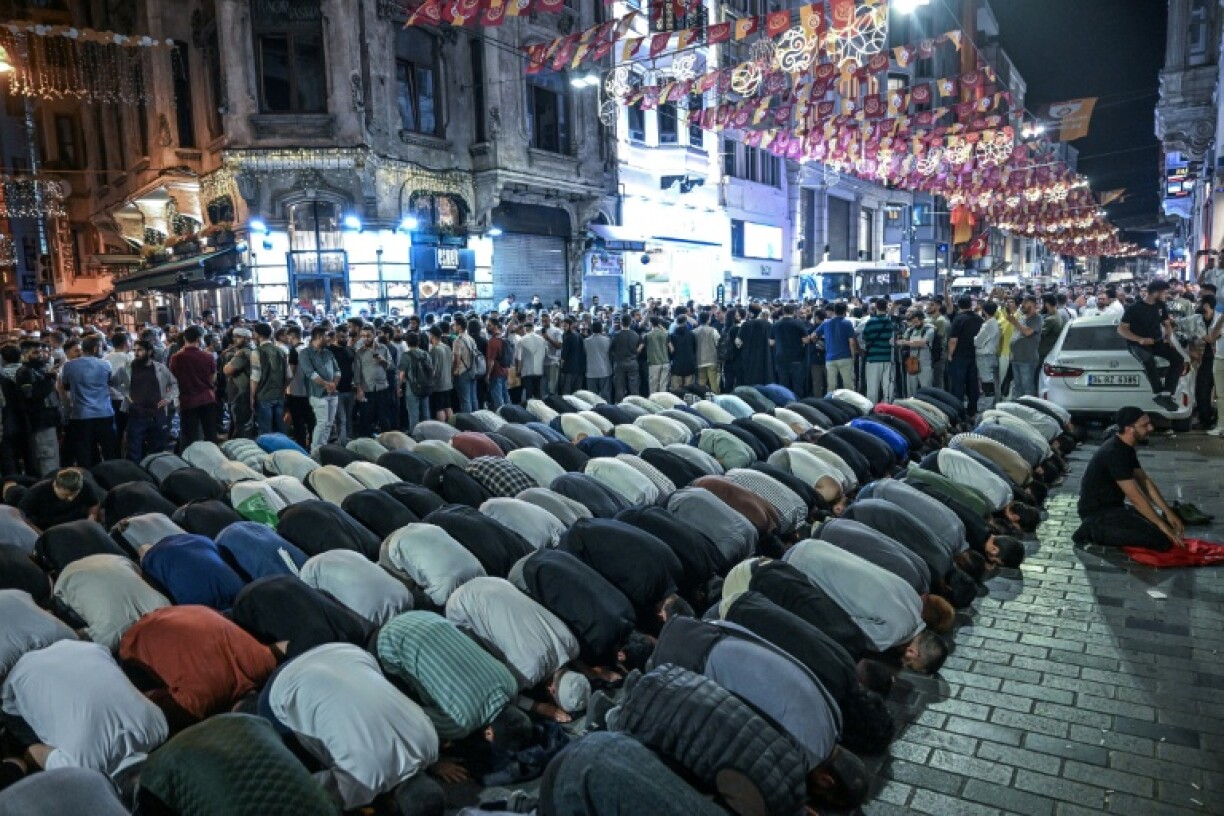 Islamist protesters pray as they gather to protest near Leman Magazine in Istanbul