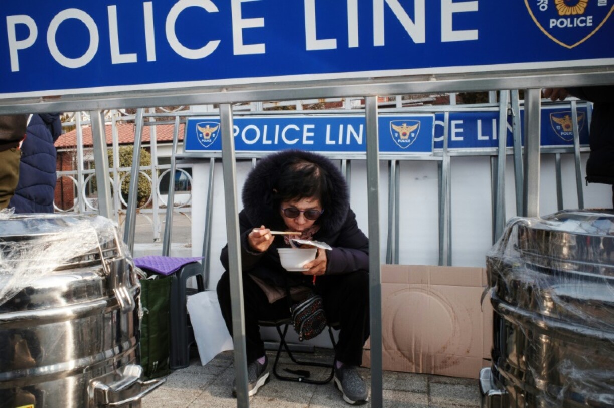 A supporter of impeached South Korea president Yoon Suk Yeol eats instant noodles on the sidelines of a rally