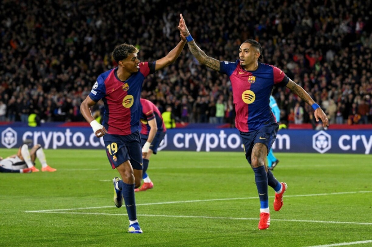 Barcelona's Brazilian forward Raphinha (R) celebrates with Lamine Yamal after scoring his team's third goal