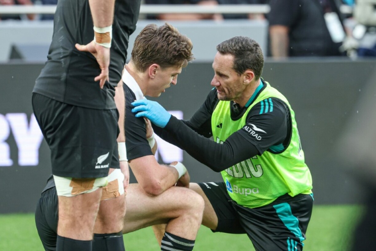 Beauden Barrett (centre) receives treatment after injuring his shoulder against Australia in the first half at Eden Park