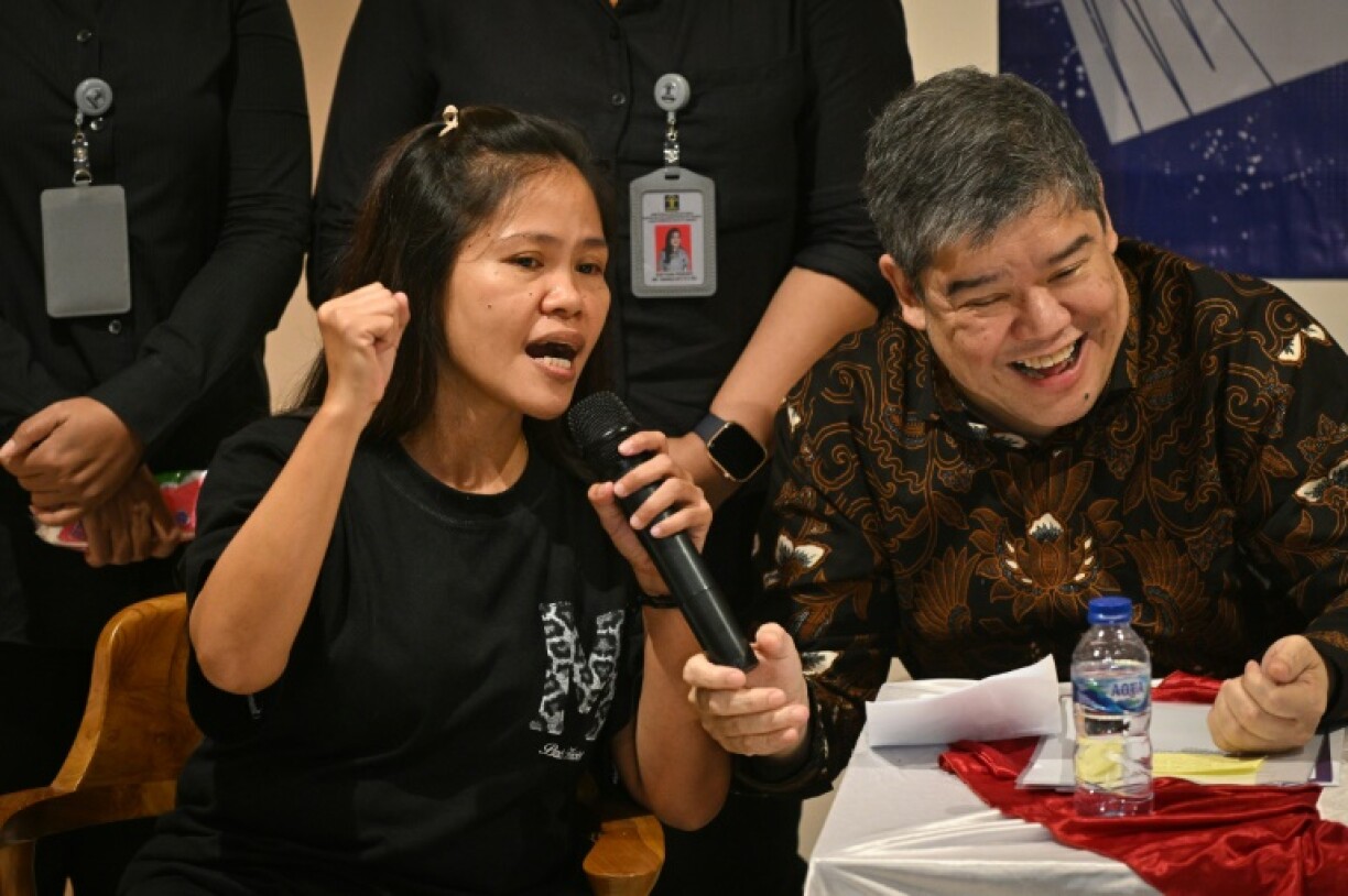 Veloso (L) and migration affairs official Eduardo Jose A. de Vega speak to reporters before her flight to Manila