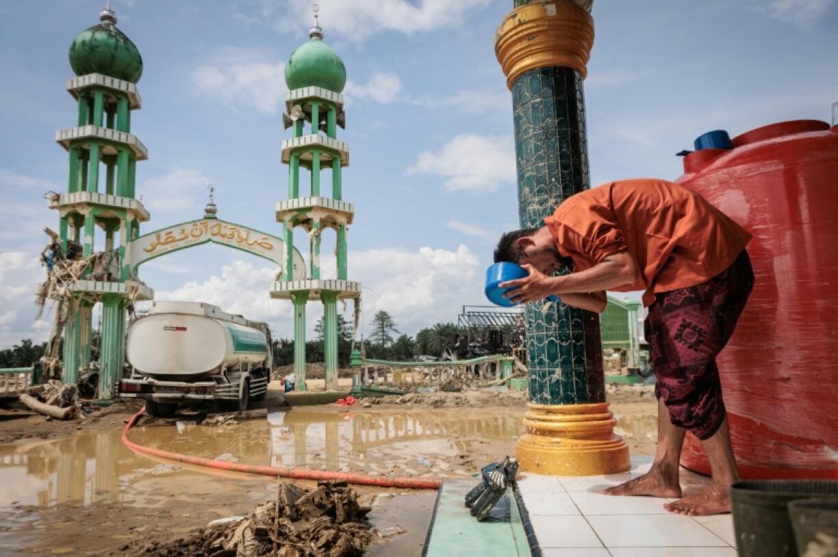 Un Indonésien fait ses ablutions avant d'aller prier dans la mosquée inondée d'Al Ihsan, à Sumatra nord, le 12 décembre 2025