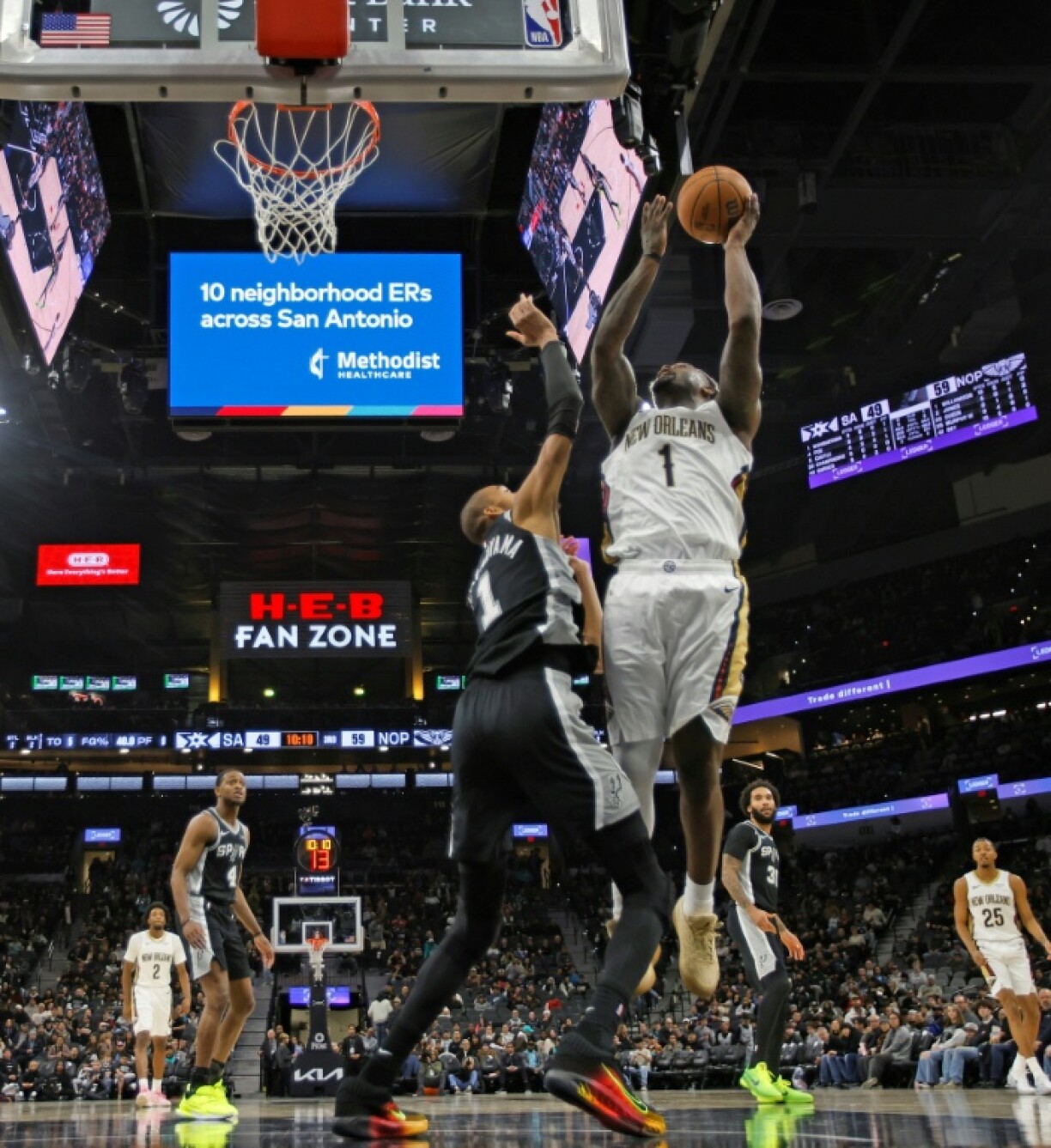 Zion Williamson (d.), l'ailier fort des New Orleans Pelicans, monte au panier devant Victor Wembanyama (c.), le pivot français des San Antonio Spurs, lors d'une rencontre de NBA, à San Antonio, le 25 janvier 2026