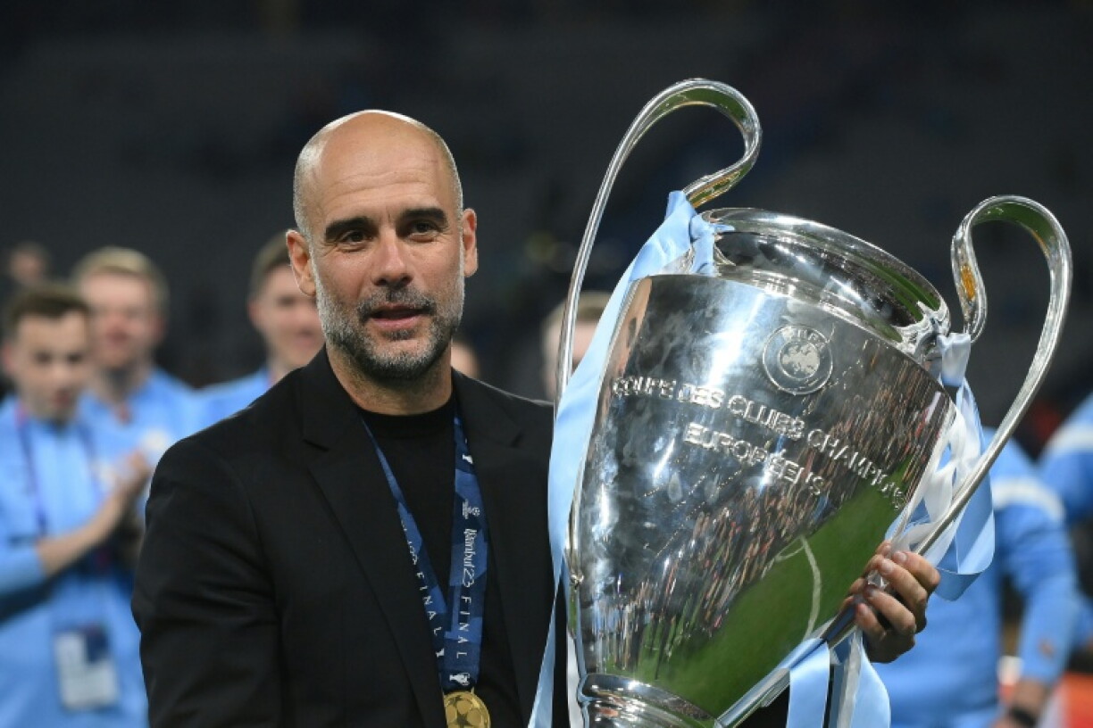 L'emblématique entraîneur de Manchester City Pep Guardiola brandit le trophée de la Ligue des champions remporté par son équipe, le 10 juin 2023 à Istanbul