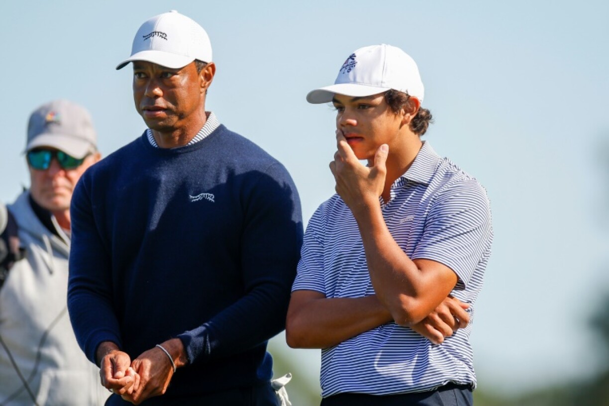Tiger Woods, left, talks with his son Charlie Woods on their way to grabbing a share of the lead after the first round of the PNC Championship parent-child event in Orlando