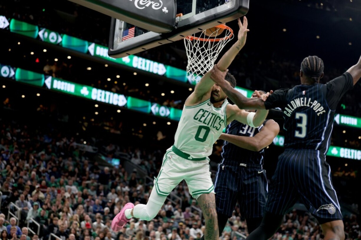 Boston Celtics forward Jayson Tatum is fouled on a dunk attempt by Orlando's Kentavious Caldwell-Pope
