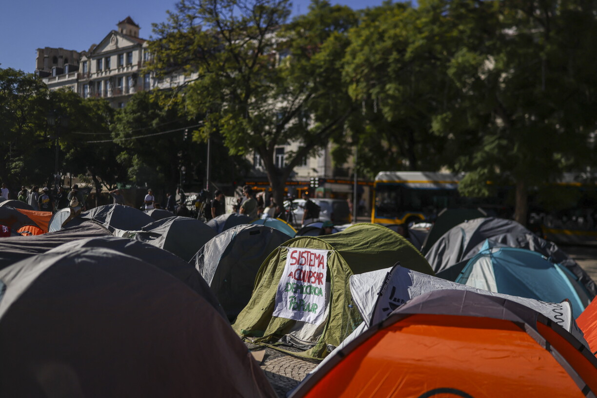 Une photo prise le 19 octobre 2026 montre une tente avec une pancarte indiquant « effondrement du système de démocratie populaire » dans un campement installé en signe de protestation contre la pénurie de logements, la flambée des loyers et les bas salaires sur la place Rossio, dans le centre de Lisbonne.