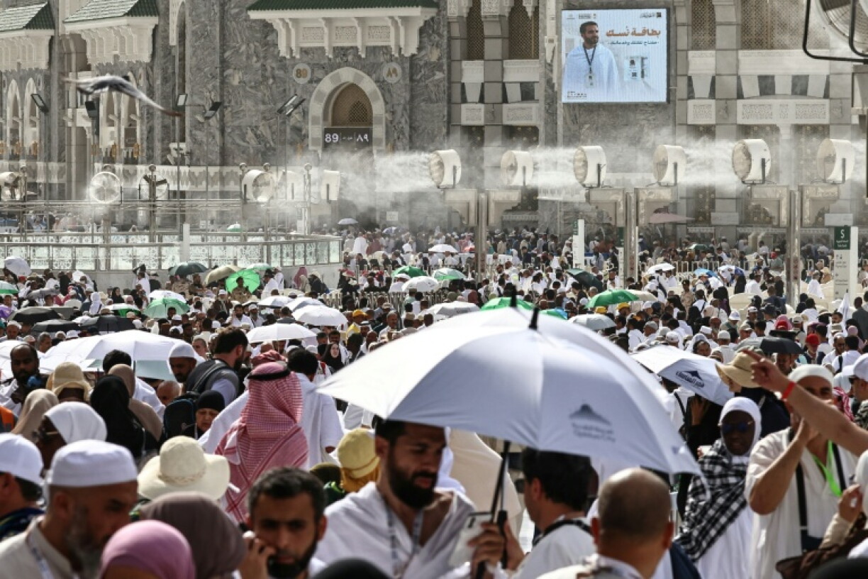 Des fidèles musulmans déambulent dans le complexe de la Grande Mosquée sous les brumisateurs installés dans la ville sainte de La Mecque, le 24 mai 2026 en Arabie saoudite, à la veille du pèlerinage annuel du Hajj