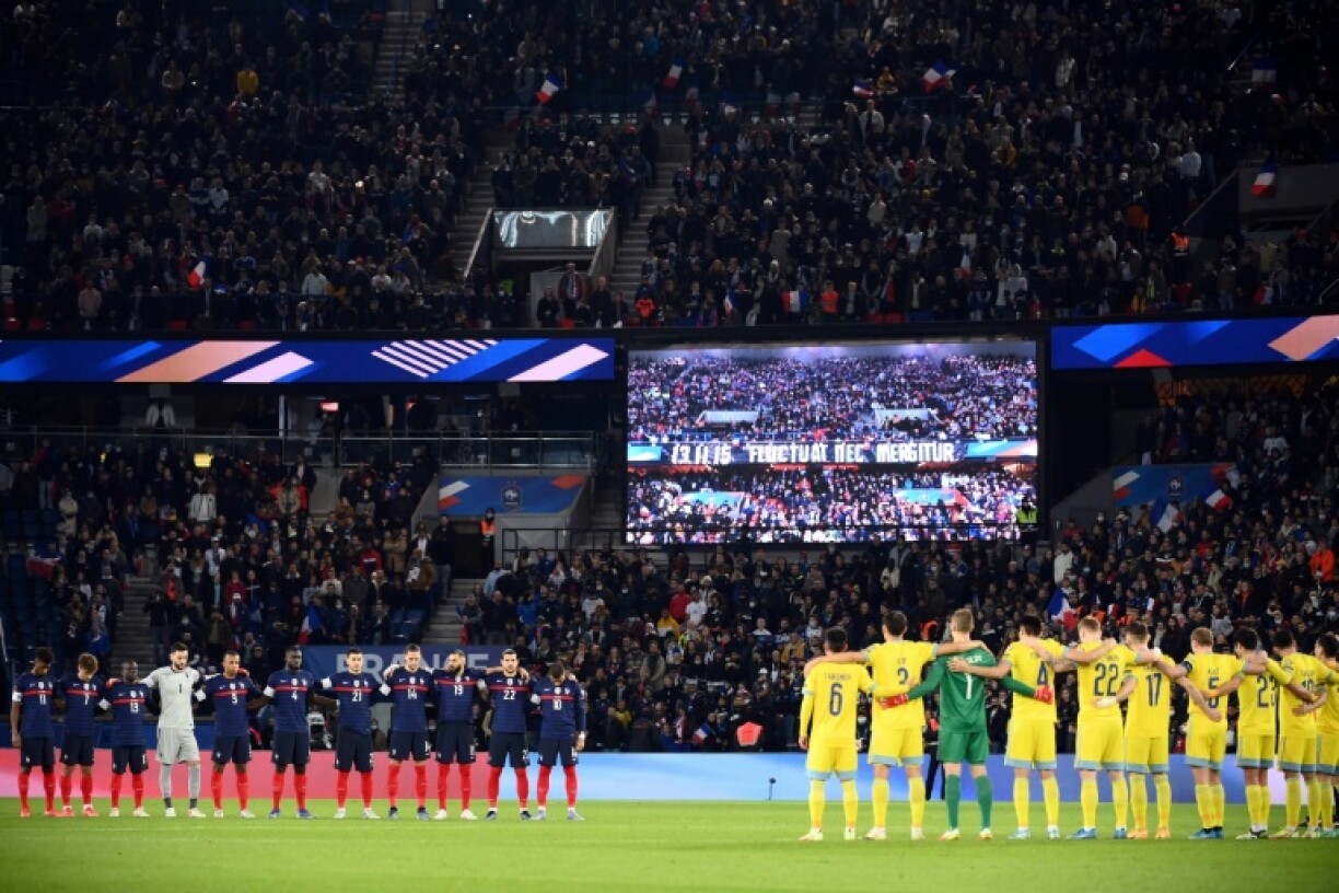 Les joueurs français et kazakhs observent une minute de silence en hommage aux victimes des attentats du 13 novembre 2015, avant le début de leur match comptant pour les éliminatoires de la Coupe du monde 2022 au Qatar, le 13 novembre 2021 au Parc des Princes à Paris