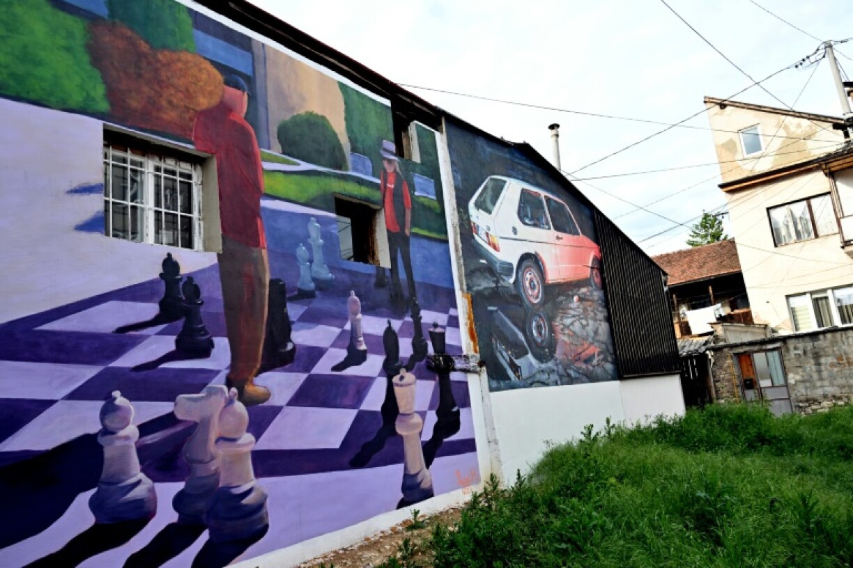 A photo shows old buildings renovated with murals by Bosnian street artist Benjamin Cengic and his creative team who seek to