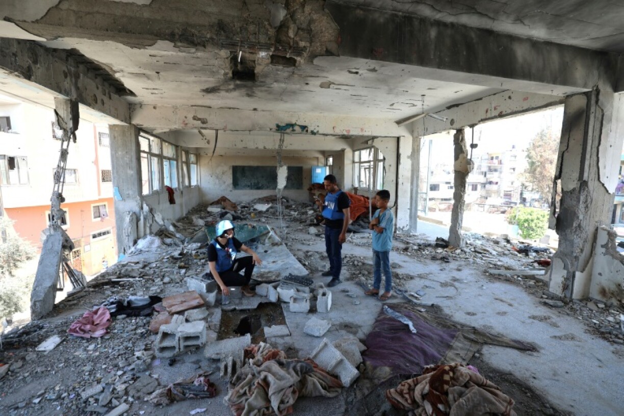 Des membres d'une équipe d'enquête des Nations unies dans les décombres d'une école de l'agence de l'ONU pour les réfugiés palestiniens (Unrwa) touchée la veille par un bombardement israélien à Nousseirat, dans le centre de la bande de Gaza, le 7 juin 2024