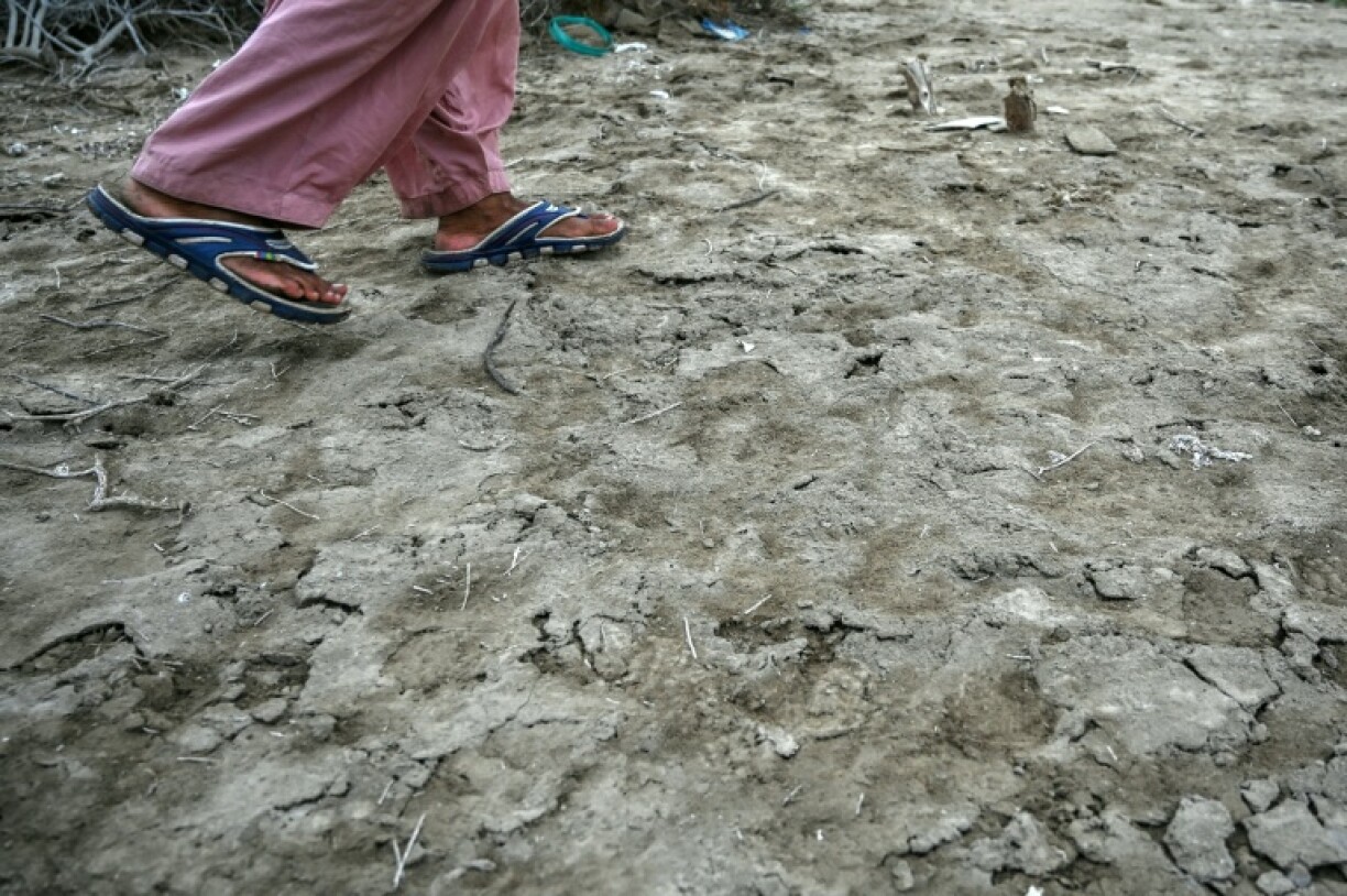 Habibullah Khatti, a local resident, walks over the salt crusts deposited in Kharo Chan town