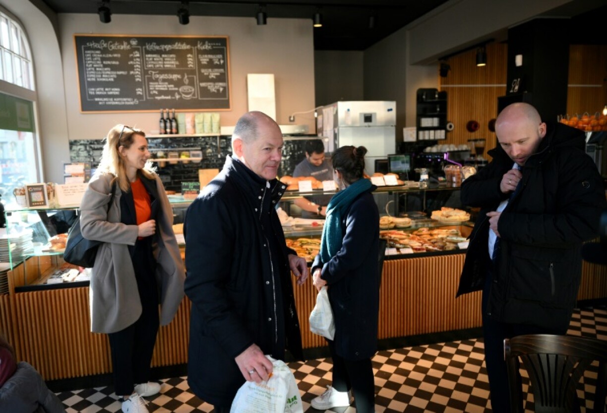 German Chancellor Olaf Scholz shops in a bakery in Potsdam, his district just outside Berlin, one day before general elections