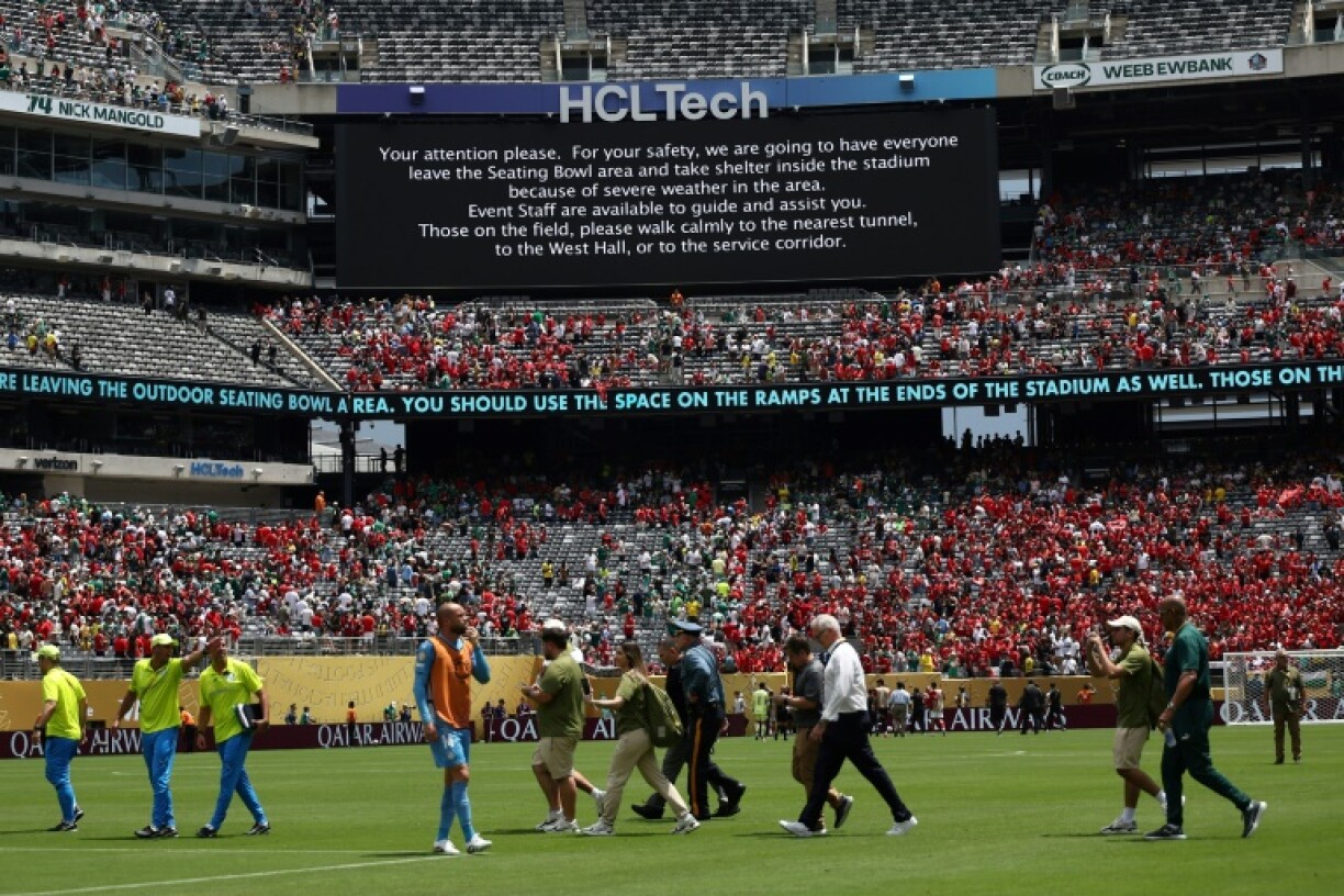 Staff are escorted off the field after a storm alert halted the Club World Cup match between Palmeiras and Al-Ahly in East Rutherford, New Jersey