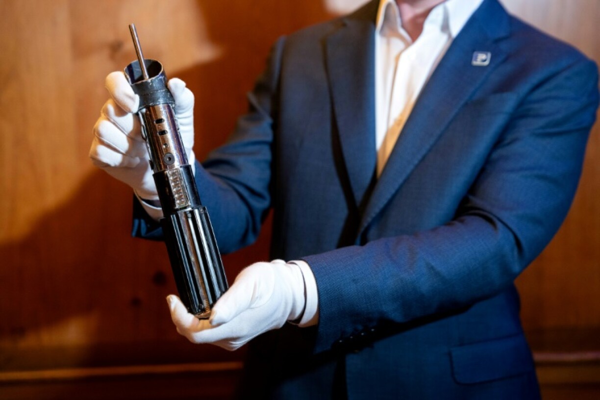 Propstore COO Brandon Alinger holds Darth Vader's lightsaber