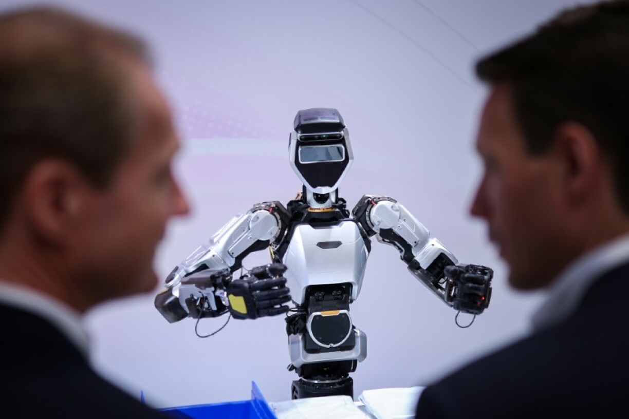 Visitors examine a humanoid robot at the booth of Microsoft and Sanctuary AI