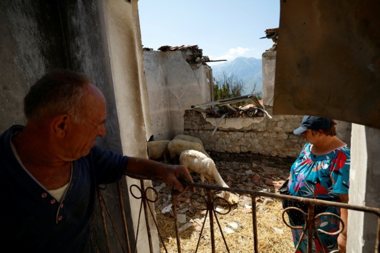 Kujtim Palloshi and his wife Mimoza stands in their house destroyed by a wildfire Gramsh