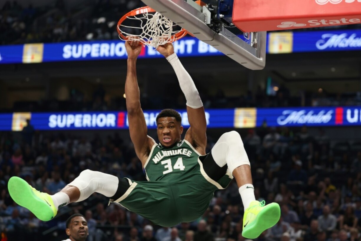 Milwaukee's Giannis Antetokounmpo hangs on the rim after a dunk in the Bucks' NBA victory over the Dallas Mavericks